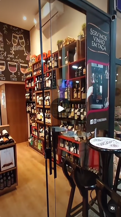 Entrada e interior da Vineria 14 com prateleiras de vinhos