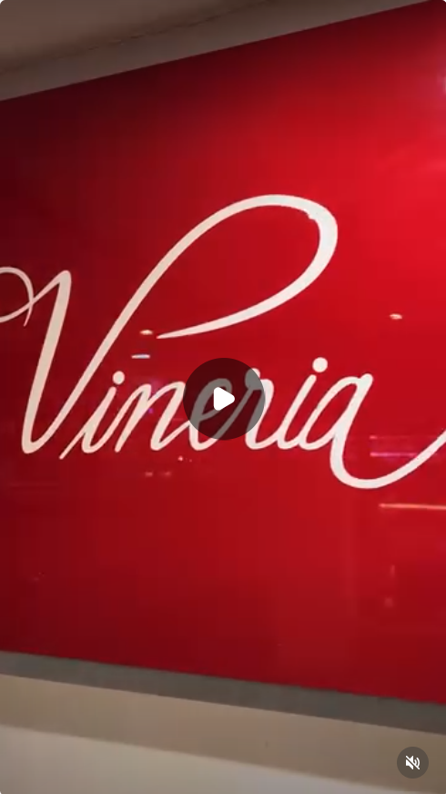Painel vermelho com o logotipo Vineria 14 na loja